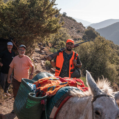 Chasseurs de lanatochasse rentrant à dos de mule après une chasse au sanglier dans les montagnes de Marrakech.