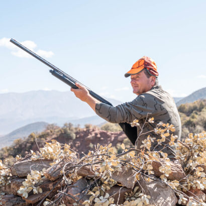 Chasseur de lanatochasse visant sa cible lors d’une chasse au sanglier dans les montagnes de Marrakech.